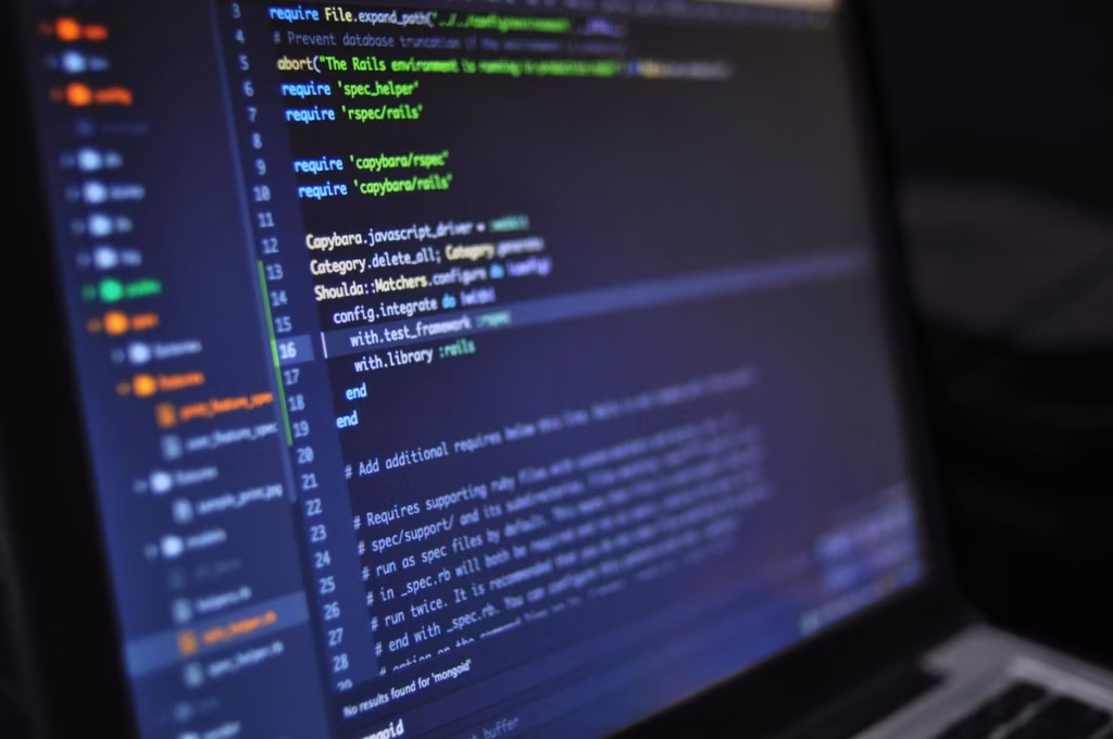 Close-up of a computer screen displaying programming code in a dark environment
