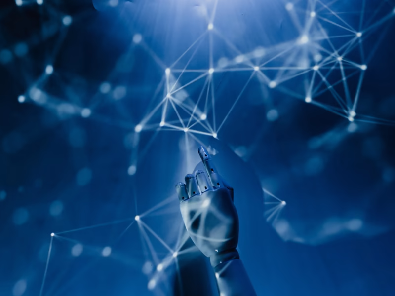 A robotic hand reaching into a digital network symbolizing AI technology